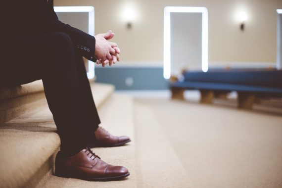 man sitting with hands folded